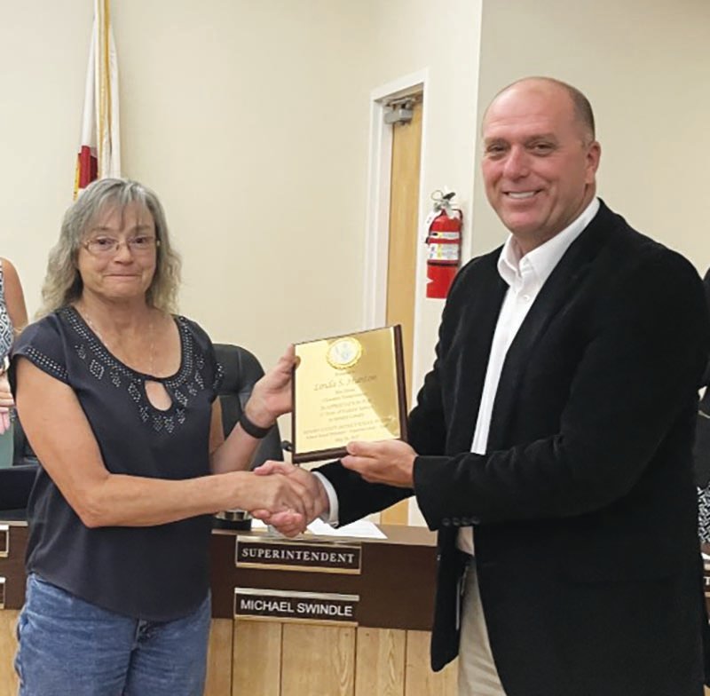 Linda Hunton receives a plaque from Hendry County School District Superintendent Michael Swindle commemorating her years of service as Hendry County School District bus driver for 33 years.